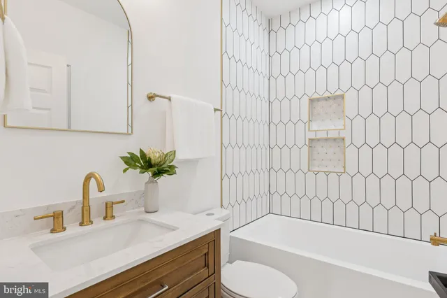a bathroom with a granite countertop sink and a bathtub