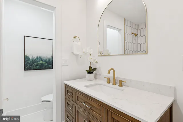 a bathroom with a sink a toilet and mirror