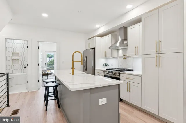 a kitchen with stainless steel appliances a sink stove and refrigerator