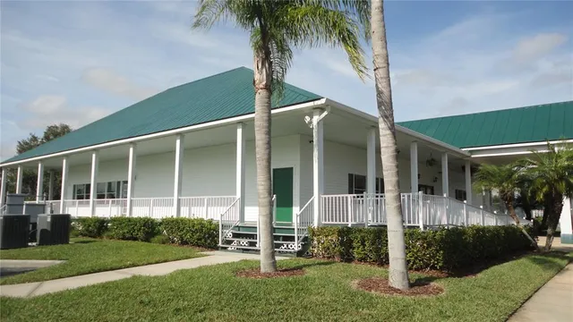 a living room with furniture pool table wooden floor and windows