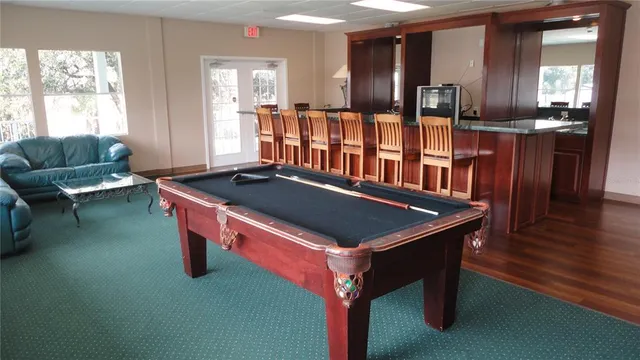 a room with pool table and windows