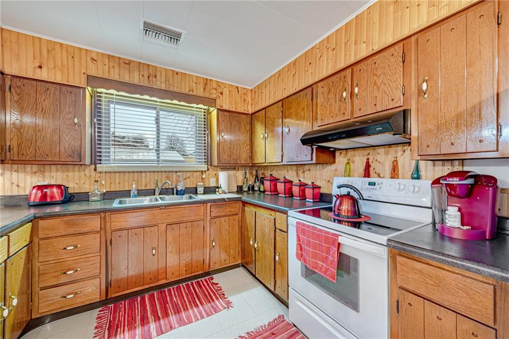 175 Mt Joy Road Mount Pleasant, PA 15666 - Photo 35 of 38 a kitchen with granite countertop a sink a stove and cabinets