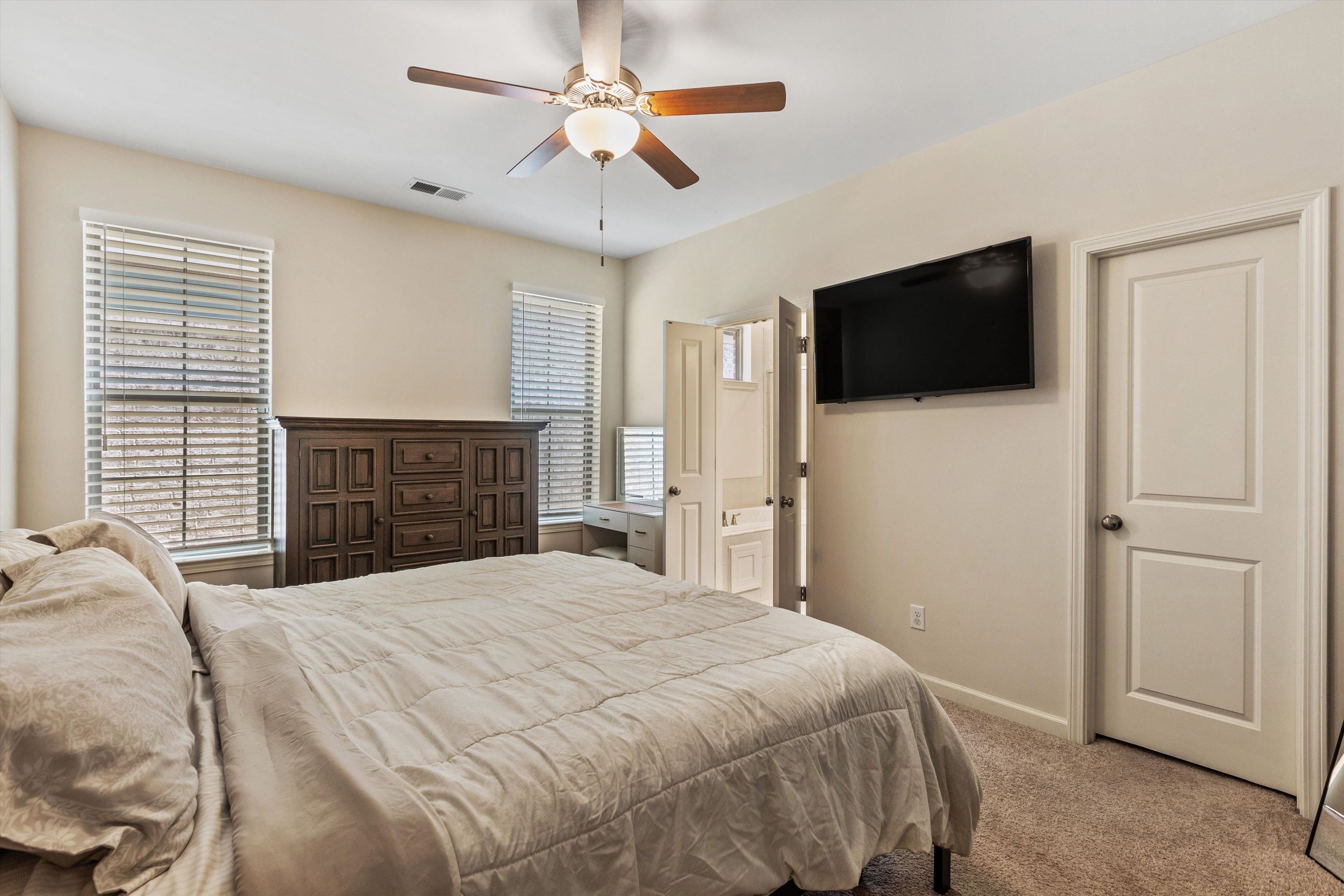 10139 Macon Road Cordova, TN 38018 - Photo 12 of 31 Carpeted bedroom featuring two windows with blinds, a ceiling fan, and a wall-mounted television