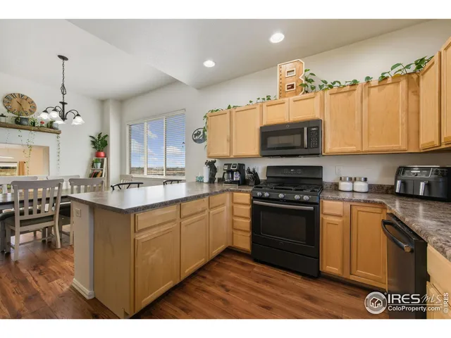 a kitchen with stainless steel appliances granite countertop a stove top oven a sink dishwasher and a microwave oven with cabinets