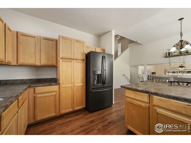 a kitchen with granite countertop a refrigerator and a sink