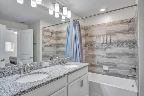 a bathroom with a granite countertop sink a mirror a shower and a bathtub