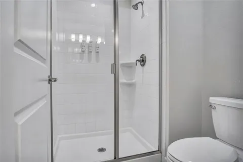 a white toilet next to a bathroom