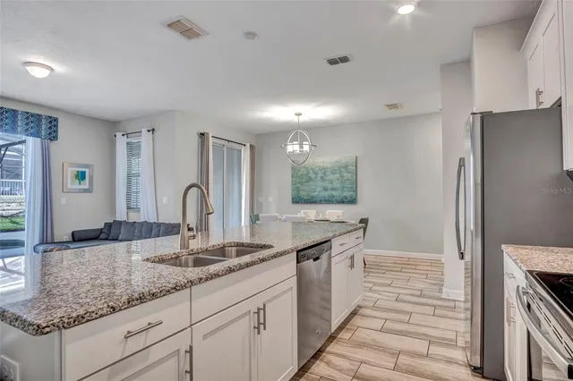 a kitchen with granite countertop a sink and a refrigerator