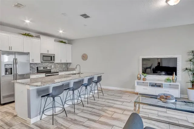 a kitchen with stainless steel appliances kitchen island granite countertop a stove and a sink