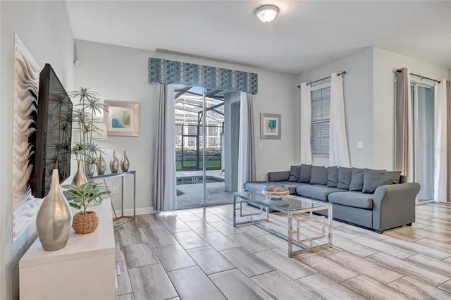 a living room with furniture and a floor to ceiling window