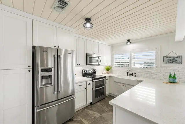 a kitchen with stainless steel appliances a refrigerator sink and cabinets