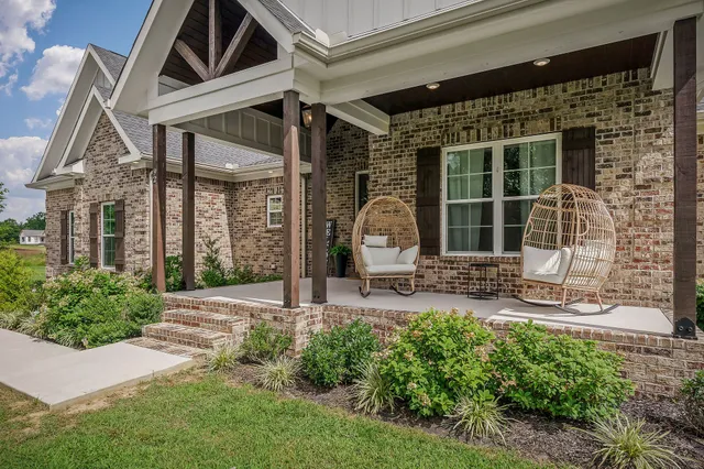 a front view of a house with outdoor seating and garden