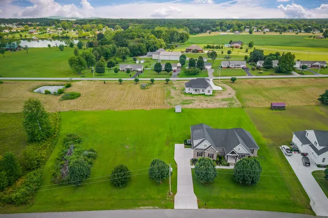 a front view of a house with a yard and trees