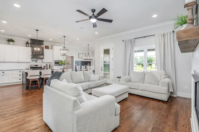 a living room with furniture kitchen and a large window