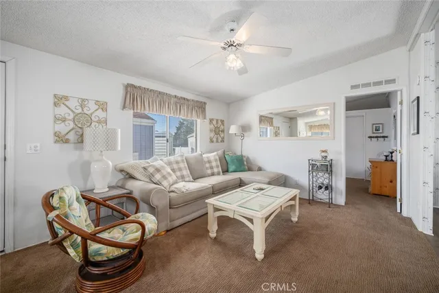 a living room with furniture a ceiling fan and a window