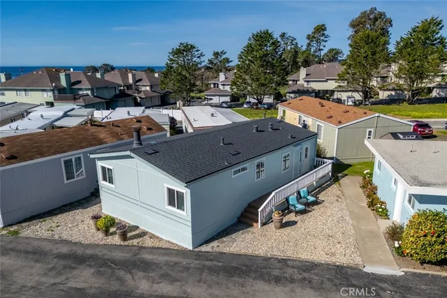 an aerial view of a house with a yard and large trees