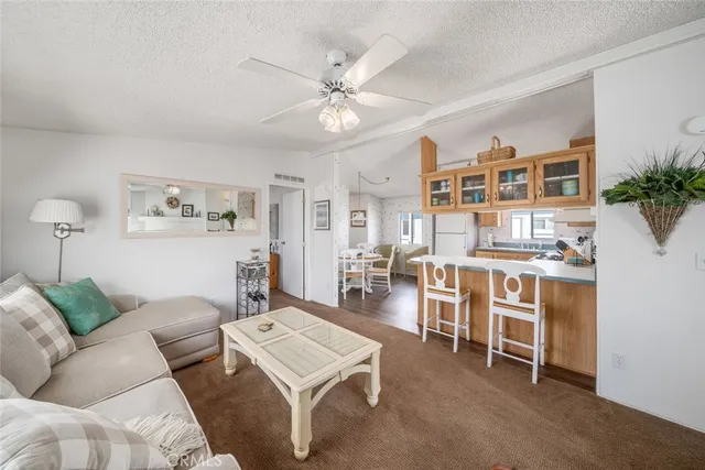 a living room with furniture and view of kitchen