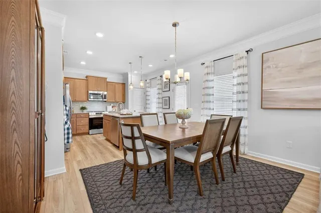 a view of a dining room and livingroom with furniture wooden floor a rug and a chandelier
