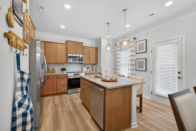 a kitchen with stainless steel appliances granite countertop a sink stove and refrigerator