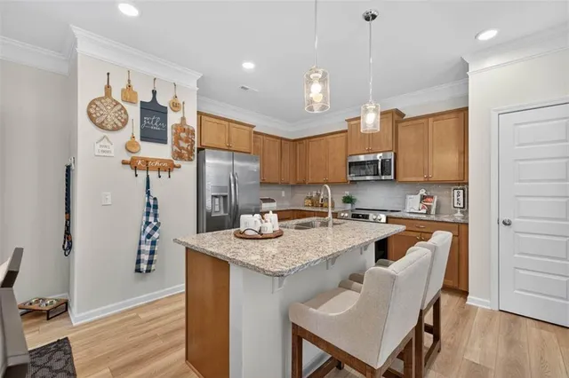 a kitchen with stainless steel appliances granite countertop a sink refrigerator and cabinets