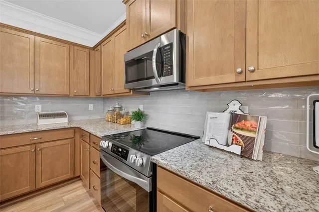 a kitchen with stainless steel appliances granite countertop a sink stove and microwave