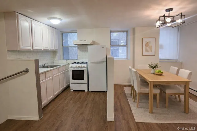 a kitchen with a table chairs refrigerator and cabinets