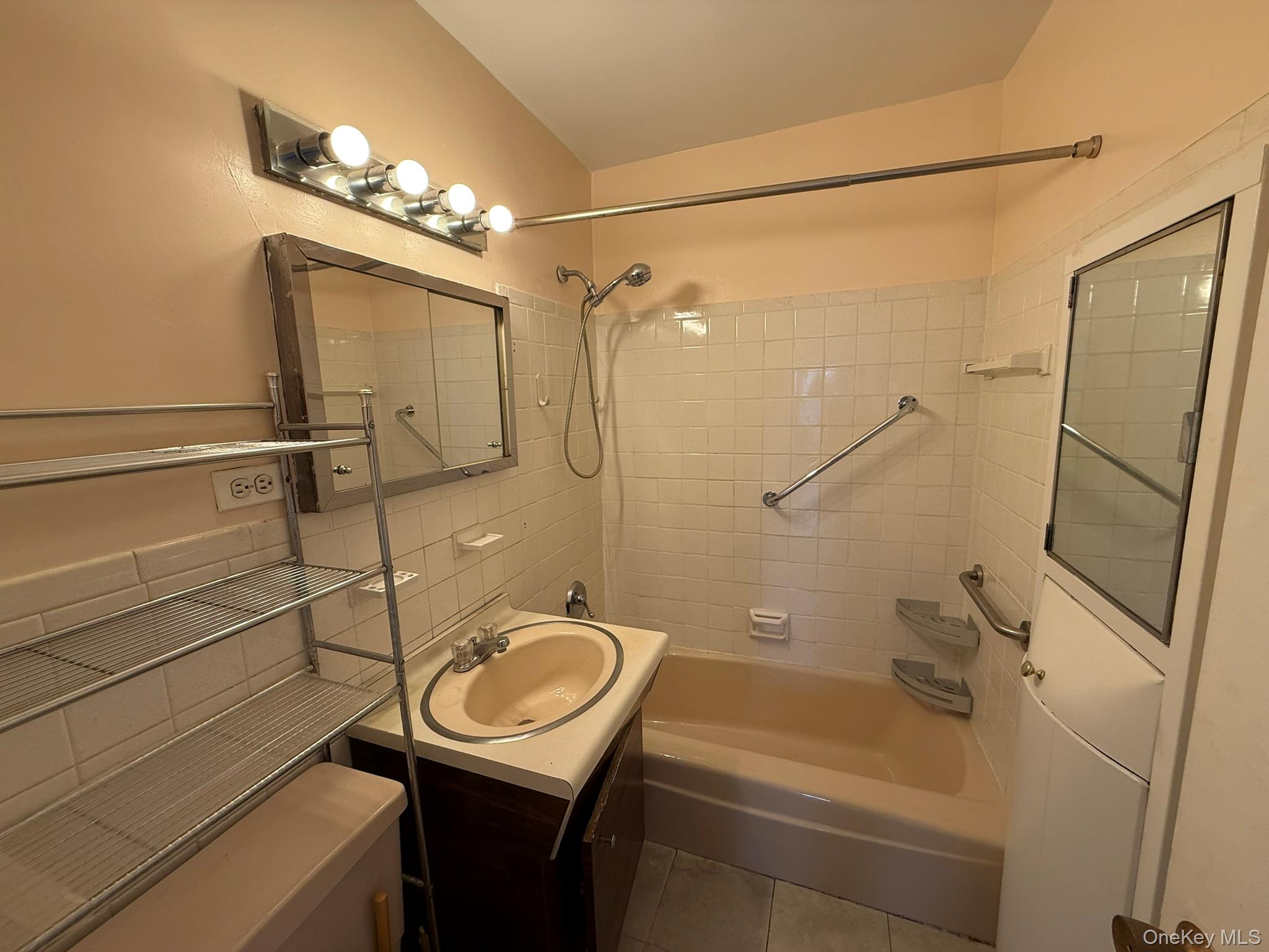 555 Kappock Street, Unit 11P Bronx, NY 10463 - Photo 13 of 15 a bathroom with a sink a mirror a bathtub and shower