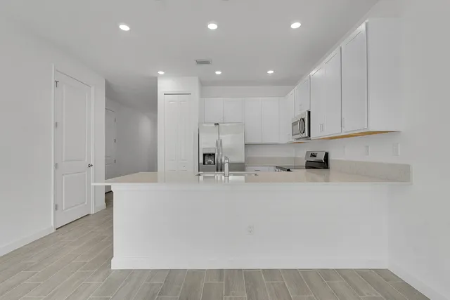 a large kitchen with stainless steel appliances and a refrigerator