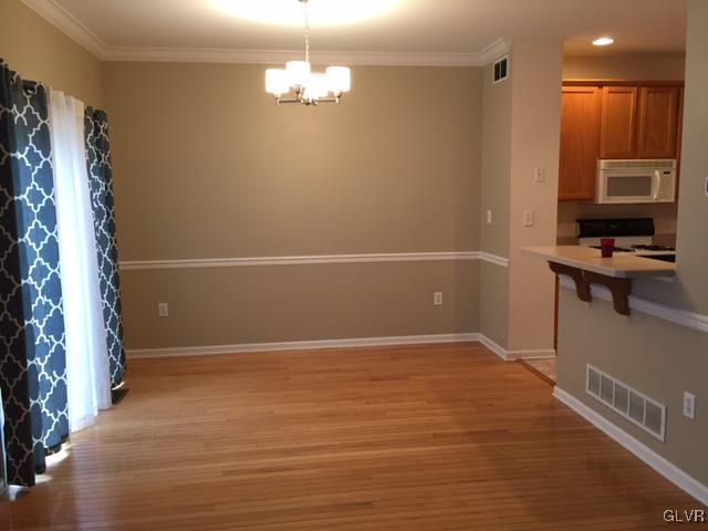 4224 Creek Road Allentown, PA 18104 - Photo 5 of 19 an empty room with wooden floor and kitchen view