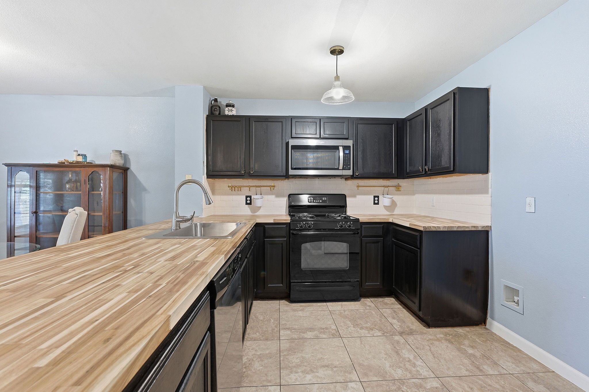 229 Black Forest Road Buda, TX 78610 - Photo 13 of 32 a kitchen with a stove a sink and a microwave