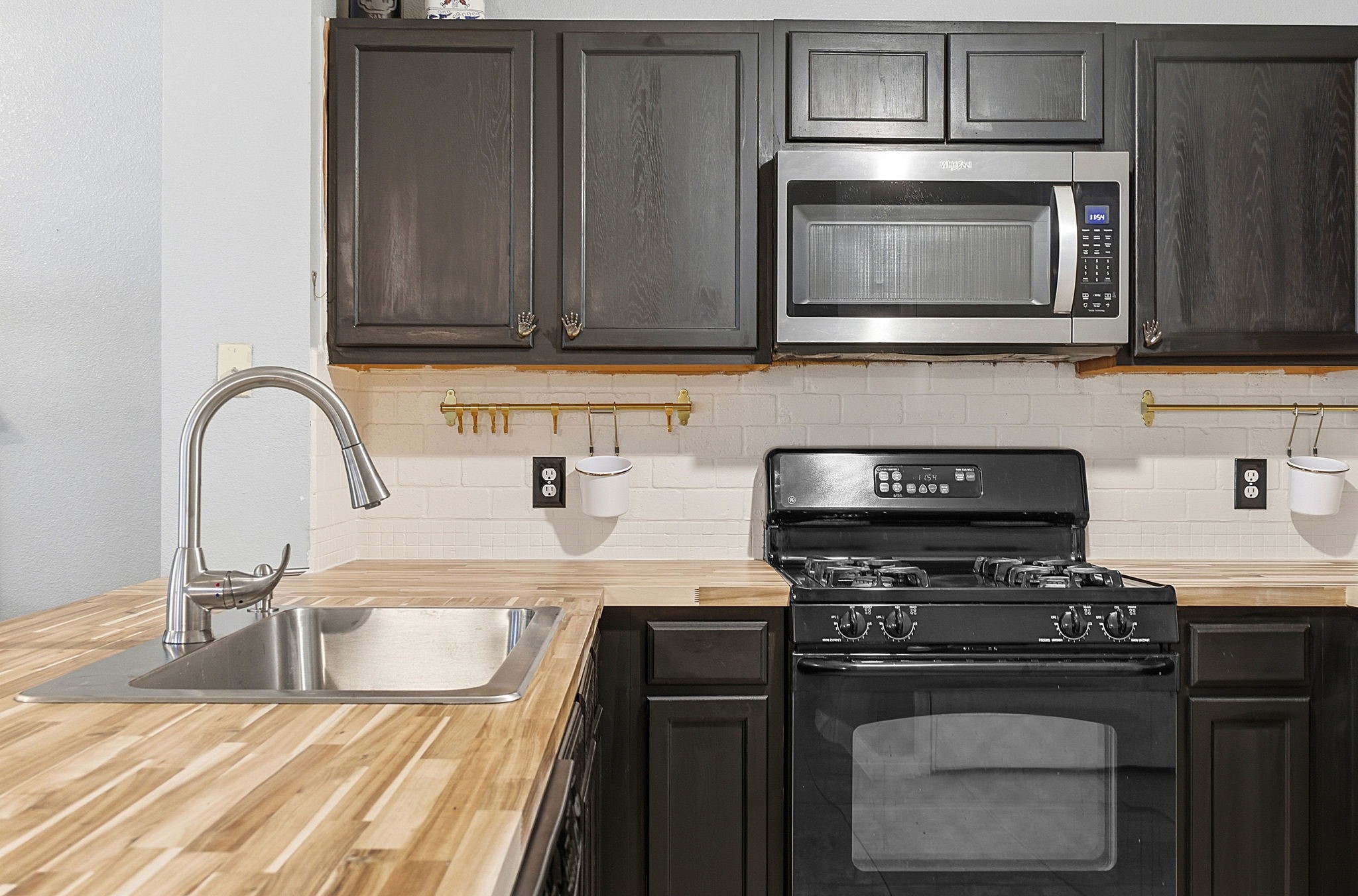 229 Black Forest Road Buda, TX 78610 - Photo 14 of 32 a kitchen with stainless steel appliances granite countertop a stove microwave and sink