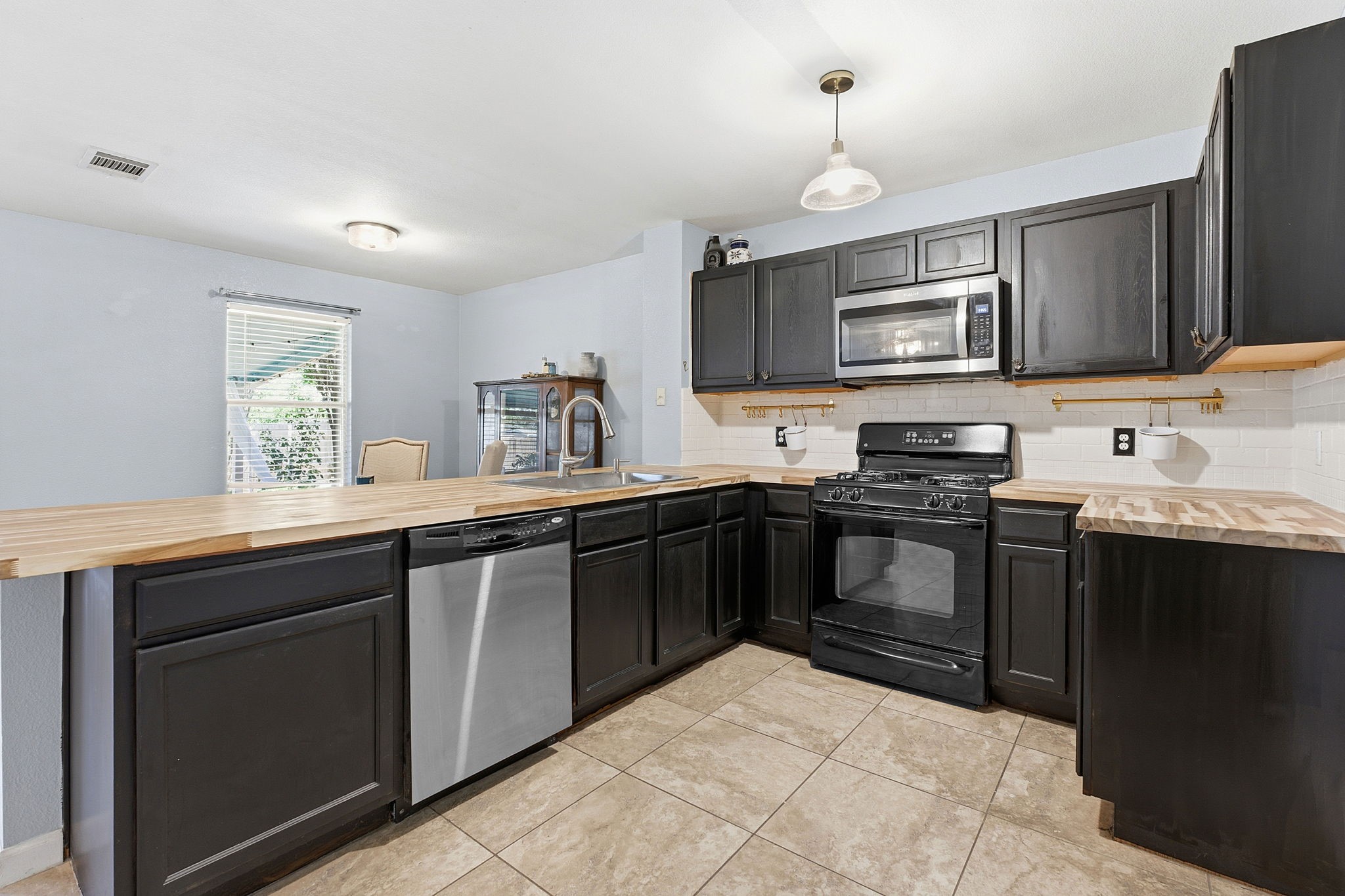 229 Black Forest Road Buda, TX 78610 - Photo 15 of 32 a kitchen with a sink stove and microwave