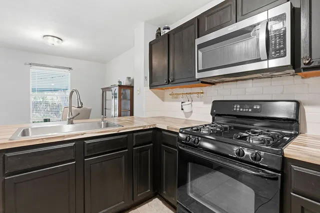 a kitchen with stainless steel appliances a sink stove and microwave
