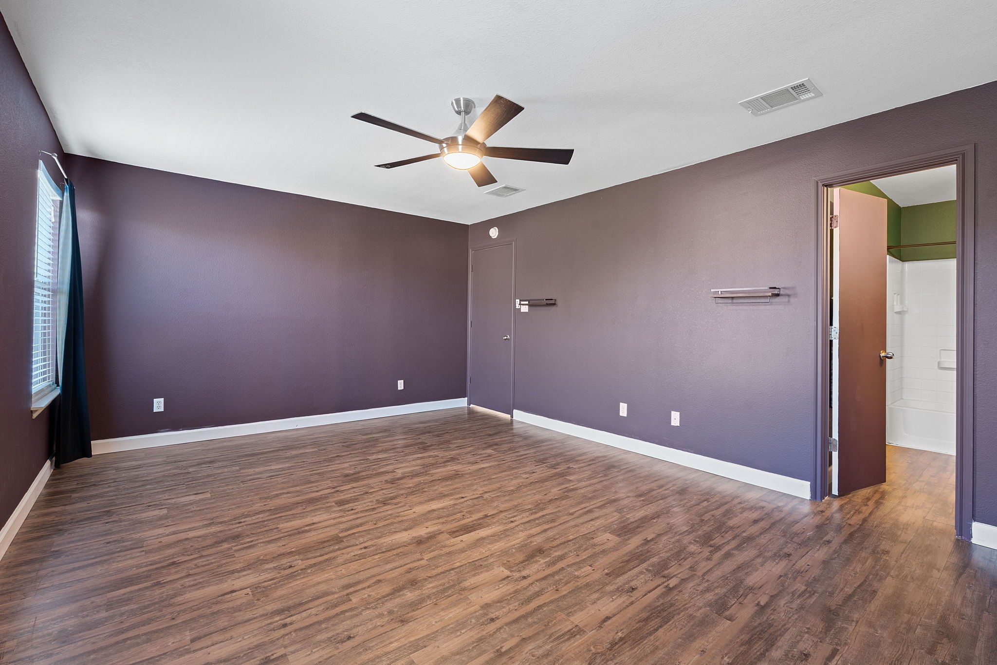229 Black Forest Road Buda, TX 78610 - Photo 18 of 32 a view of an empty room with wooden floor and a ceiling fan