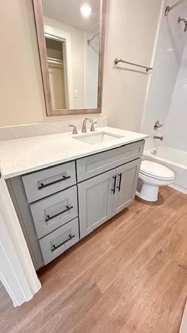 a view of a pathway that has potted plants and a large tree