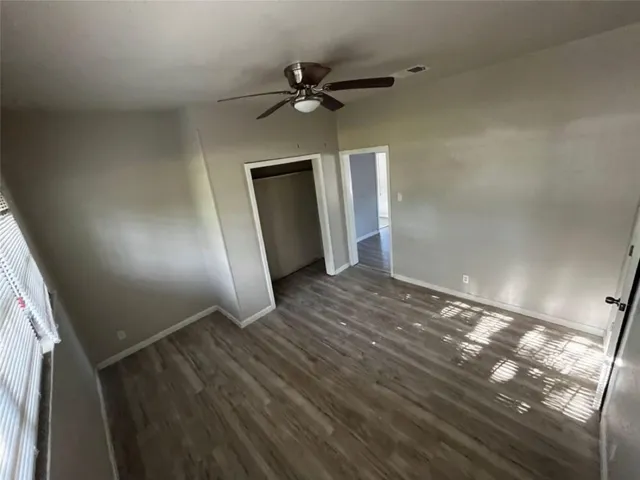a view of empty room with wooden floor