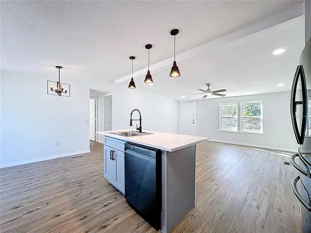 a kitchen with a sink stove and wooden floor