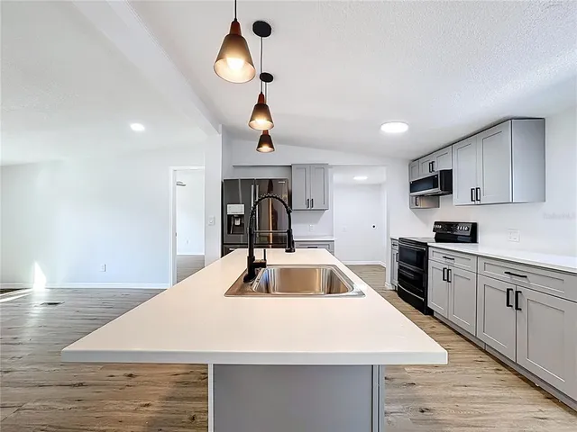 a kitchen with stainless steel appliances kitchen island a white counter space a sink and appliances