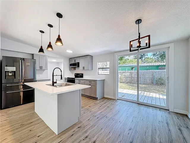 a kitchen with stainless steel appliances granite countertop a stove and wooden floor