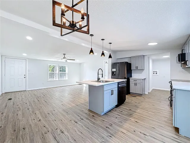 a large kitchen with cabinets wooden floor and a sink