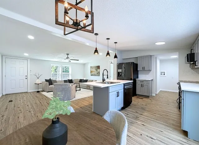 a large kitchen with cabinets a sink dishwasher a stove and a refrigerator with wooden floor