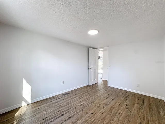 a view of an empty room and wooden floor