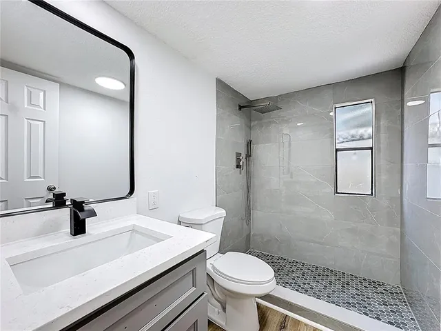 a bathroom with a sink toilet a mirror and shower