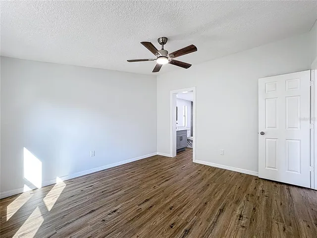 a view of a room with wooden floor and a ceiling fan