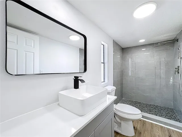 a bathroom with a sink a toilet and shower