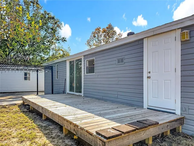 a view of a backyard with a wooden roof and a table and chair