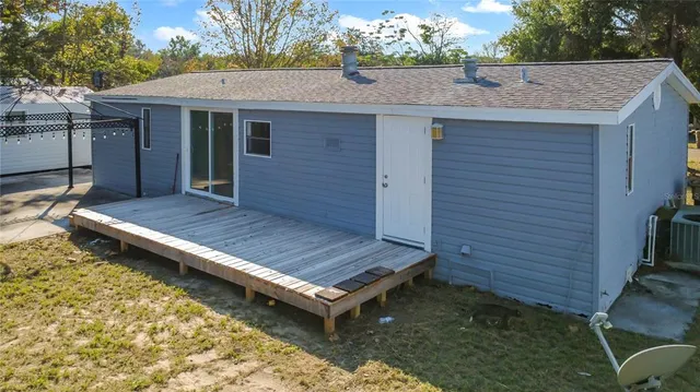 a view of wooden house with a yard and wooden fence