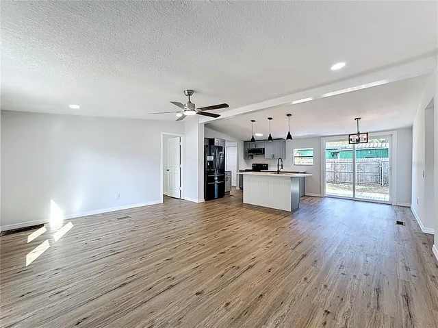 a view of a kitchen with wooden floor and a window