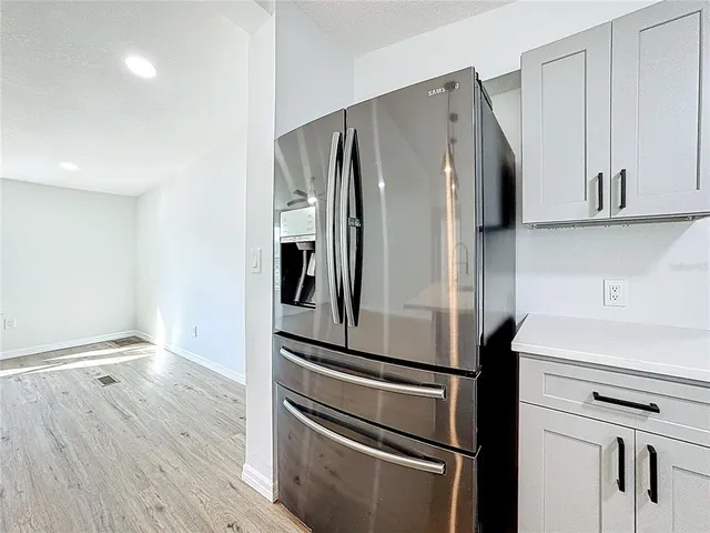 a metallic refrigerator freezer sitting in a kitchen