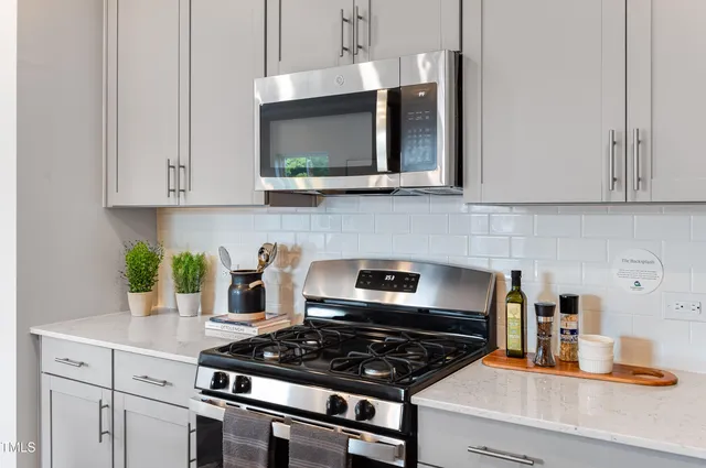 a kitchen with stainless steel appliances granite countertop a stove a microwave and cabinets